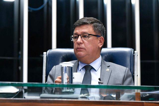 Carlos Viana, candidato ao governo de Minas Gerais pelo PL. Ele é pardo, tem cabelo curto e olha para o lado, sentado na mesa diretora do plenário no Senado Federal - Metrópoles