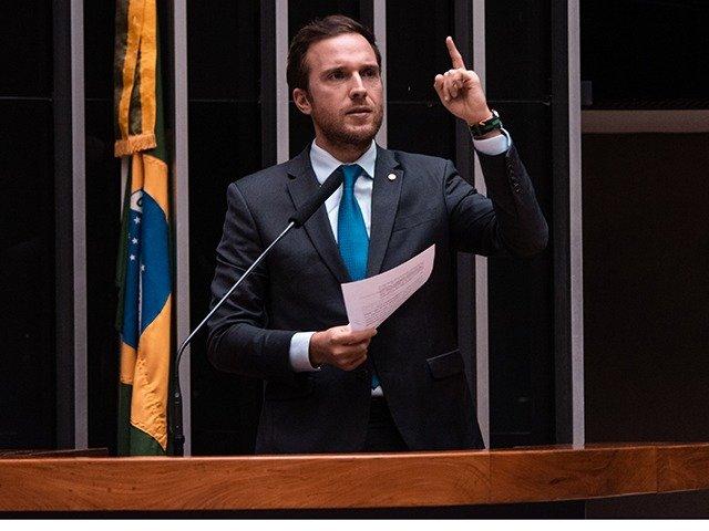 Vinícius Poit, candidato ao governo de São Paulo pelo Novo. Ele é branco, tem cabelo liso, curto e escuro e discursa na tribuna da Câmara dos Deputados, com papel na mão - Metrópoles